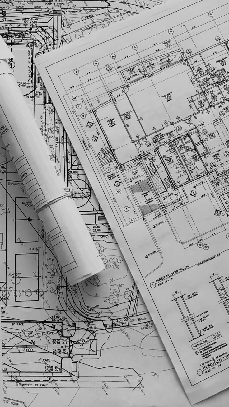 Architectural blueprints and floor plan drawings on a UNC project desk